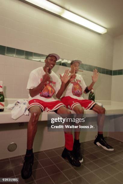 Finals: Closeup of Chicago Bulls Michael Jordan and Scottie Pippen victorious, smoking cigar in locker room after winning Game 6 and championship vs...