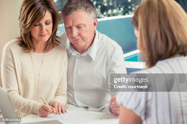 senior couple meeting with financial advisor. - lawyers serious stock pictures, royalty-free photos & images