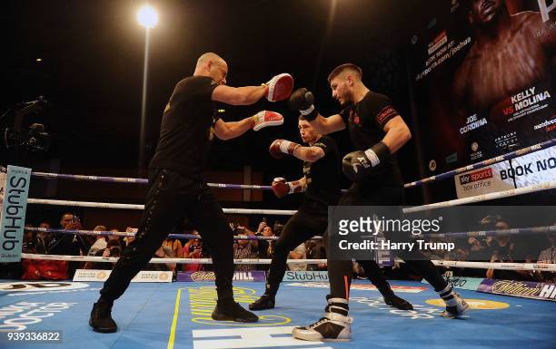 Boxer Josh Kelly and Ryan Burnett work out with Trainer Adam Booth during Anthony Joshua And Joseph Parker Media Workouts at St David's Hall on March...