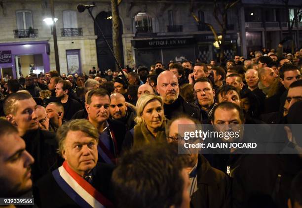 President of the French far-right Front National party Marine Le Pen walks with others in Paris on March 28 during a silent march in memory of...