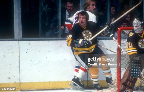 Brad Park of the Boston Bruins checks Bob Nystrom of the New York Islanders as goalie Gerry Cheevers of the Bruins defends the net during an NHL game...