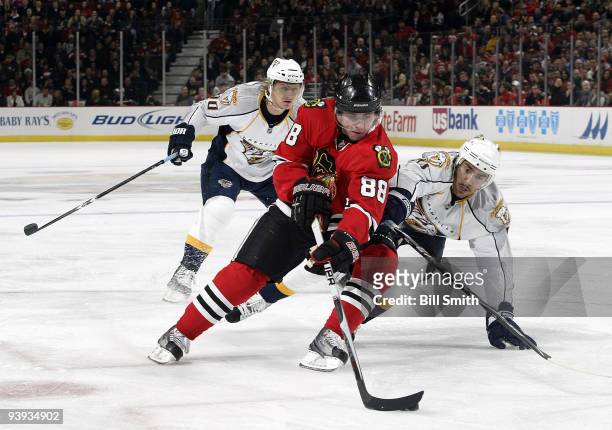 Patrick Kane of the Chicago Blackhawks takes control of the puck as Francis Bouillon of the Nashville Predators reaches around and Martin Erat of the...