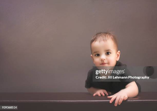 portrait of a smirking / smiling brunette 20 month old boy toddler in studio - mouth smirk stock pictures, royalty-free photos & images