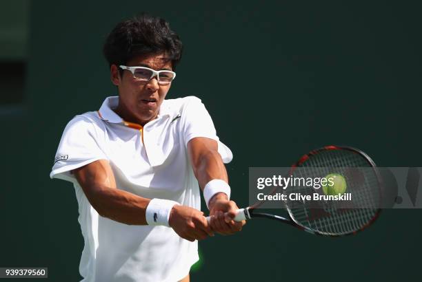 Hyeon Chung of Korea plays a backhand against John Isner of the United States in their quarter final match during the Miami Open Presented by Itau at...