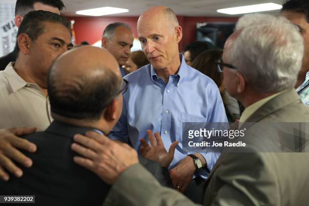 Florida Governor Rick Scott interacts with people at Restaurant El Arepazo 2 as he holds a bill signing ceremony for legislation to prohibit all...