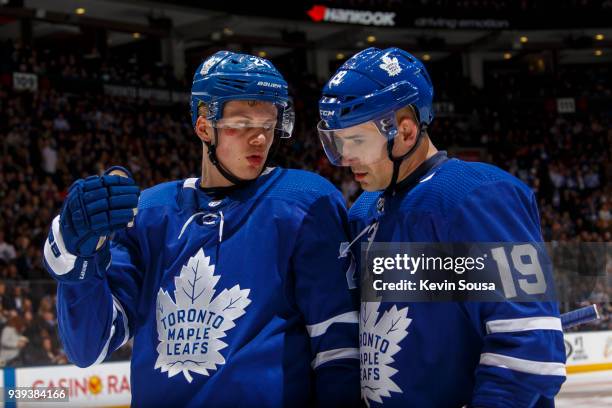 Kasperi Kapanen of the Toronto Maple Leafs talks to teammate Tomas Plekanec at an NHL game against the Buffalo Sabres during the second period at the...