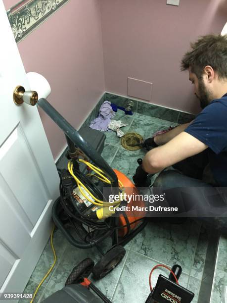 plumber pushing a camera into toilet hole to find out where the sanitary drain is clogged - drain camera stock pictures, royalty-free photos & images