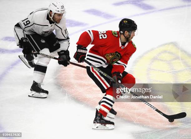 Jordan Oesterle of the Chicago Blackhawks advances the puck in front of Alex Iafallo of the Los Angeles Kings at the United Center on February 19,...