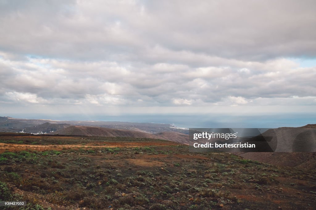 Scenic View Of Mountains Against Cloudy Sky