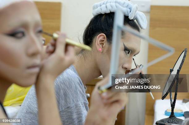 In this photograph taken on March 24 Vietnamese drag queens Betty and Vanessa prepare backstage before a show at a local bar in Hanoi. A vanguard of...