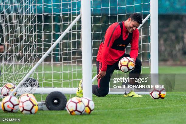 This picture taken on March 21, 2018 shows Shanghai's SIPG forward Brazilian Hulk trying to catch a ball during a training session in Shanghai. / AFP...