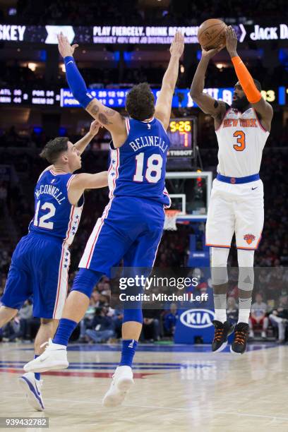 Tim Hardaway Jr. #3 of the New York Knicks shoots the ball against T.J. McConnell and Marco Belinelli of the Philadelphia 76ers in the third quarter...