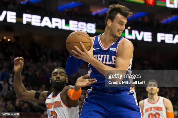 Dario Saric of the Philadelphia 76ers grabs a rebound against Tim Hardaway Jr. #3 of the New York Knicks in the third quarter at the Wells Fargo...