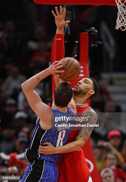 Denzel Valentine of the Chicago Bulls fouls Mario Hezonja of the Orlando Magic at the United Center on February 12, 2018 in Chicago, Illinois. The...