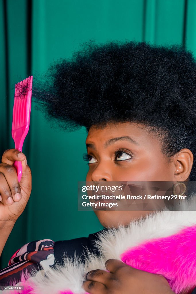 Beauty Portrait of Young Confident Woman with Afro Styling Her Hair with Pick