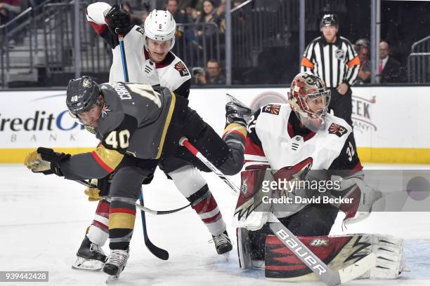 Jakob Chychrun and Antti Raanta of the Arizona Coyotes defend their goal against Ryan Carpenter of the Vegas Golden Knights during the game at...