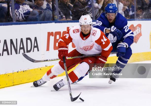 Gustav Nyquist of the Detroit Red Wings skates the puck against Nikita Zaitsev of the Toronto Maple Leafs during the first period at the Air Canada...