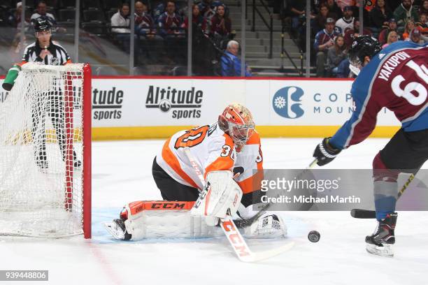 Goaltender Michal Neuvirth of the Philadelphia Flyers looks to make a save against Nail Yakupov of the Colorado Avalanche at the Pepsi Center on...