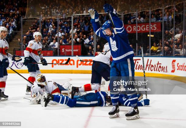 Tyler Bozak of the Toronto Maple Leafs celebrates a goal by teammate James van Riemsdyk as Roberto Luongo of the Florida Panthers looks back during...