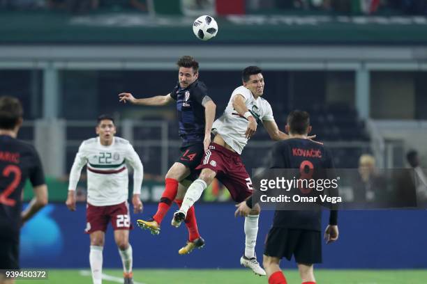 Jesus Molina of Mexico and Duje Cop of Croatia heads for the ball during the international friendly match between Mexico and Croatia at AT&T Stadium...