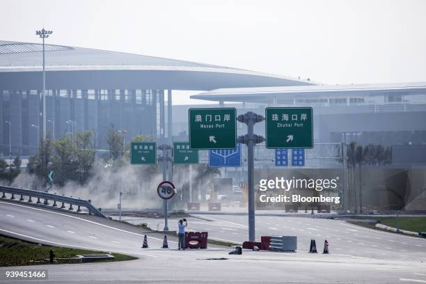Road signs directing traffic to the Macao Port and Zhuhai Port stand near the Zhuhai entrance to the Hong Kong-Zhuhai-Macau Bridge during a media...