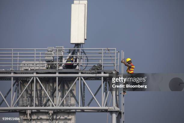 Worker walks down a ladder of a sign post at a section of the Hong Kong-Zhuhai-Macau Bridge during a media tour of the bridge offshore in Zhuhai,...