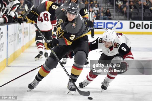 Brayden McNabb of the Vegas Golden Knights skates with the puck while Clayton Keller of the Arizona Coyotes defends during the game at T-Mobile Arena...