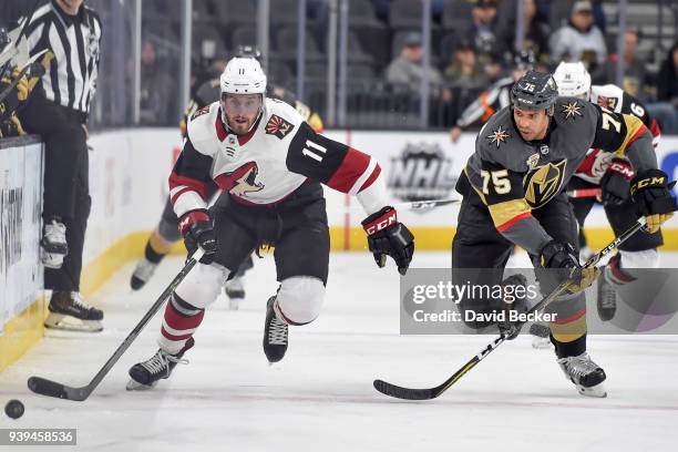 Brendan Perlini of the Arizona Coyotes and Ryan Reaves of the Vegas Golden Knights skate to the puck during the game at T-Mobile Arena on March 28,...