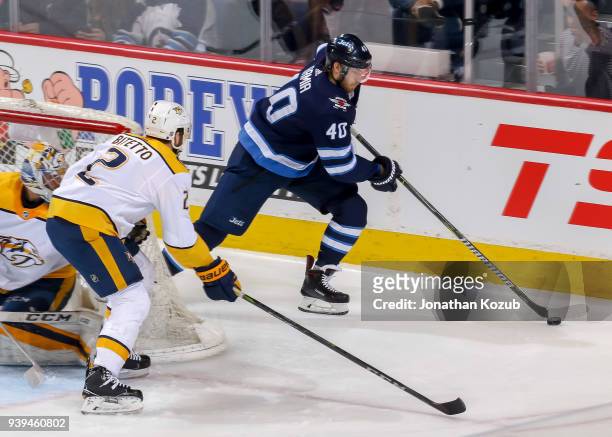 Joel Armia of the Winnipeg Jets plays the puck behind the net as Anthony Bitetto of the Nashville Predators defends during second period action at...