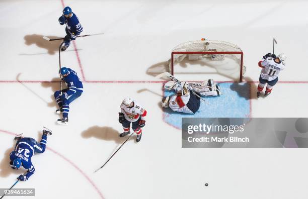 Auston Matthews of the Toronto Maple Leafs celebrates his goal with teammates Zach Hyman and William Nylander, as Roberto Luongo of the Florida...