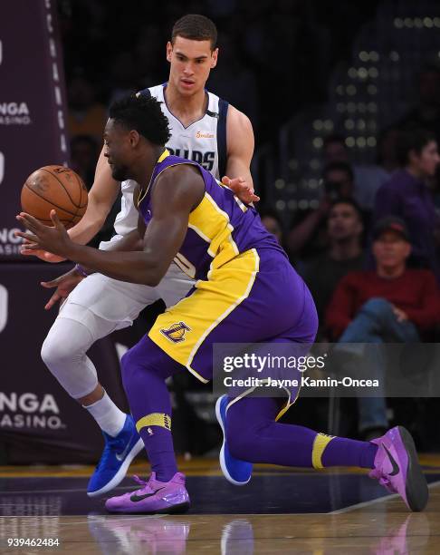 Dwight Powell of the Dallas Mavericks defends Julius Randle of the Los Angeles Lakers as he drives to the basket in the first half of the game at...