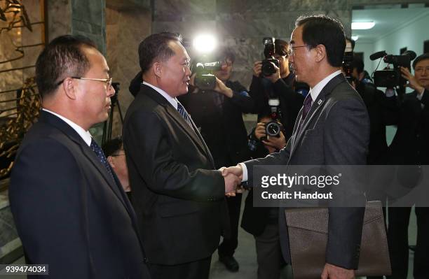 In this handout photo, South Korean Unification Minister Cho Myoung-Gyon shakes hands with North Korean delegation head Ri Son-Gwon before their...
