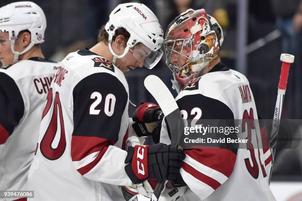 Dylan Strome and Antti Raanta of the Arizona Coyotes celebrate after defeating the Vegas Golden Knights at T-Mobile Arena on March 28, 2018 in Las...