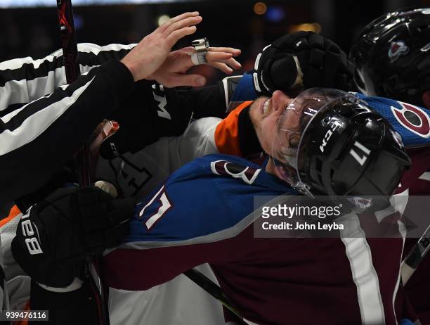Colorado Avalanche center Tyson Jost gets a glove in the face by Philadelphia Flyers defenseman Andrew MacDonald at the end of regulation during a...