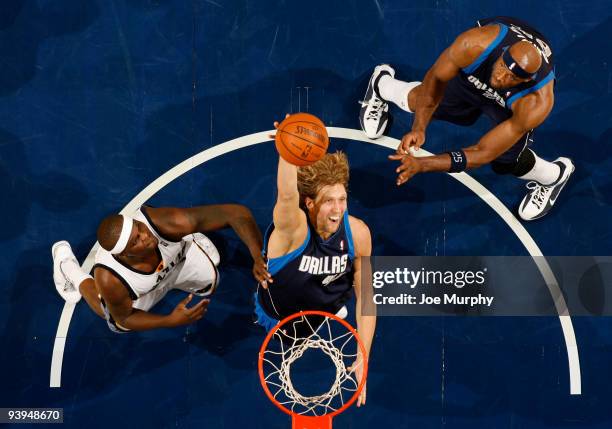 Dirk Nowitzki of the Dallas Mavericks rebounds the basketball against Zach Randolph of the Memphis Grizzlies on December 4, 2009 at FedExForum in...