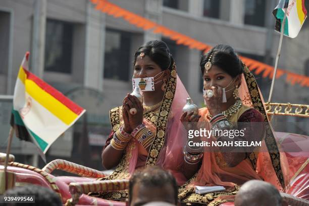 Indian devotees from the Jain community ride in a carriage during a procession at an event to mark Mahavir Jayanti at the Sri Mahavir Jain Temple in...