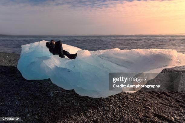 one man sleeping on ice berg, iceland - jökulsárlón lagoon fotografías e imágenes de stock