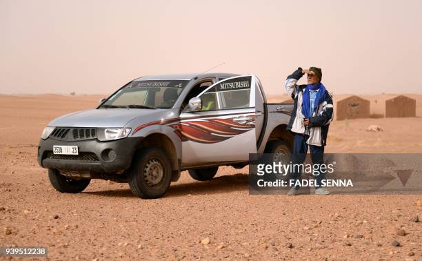 Meteorite hunter steps out of his vehicle as he searches for rocks near the oasis town of Mhamid el-Ghizlane, in southern Morocco's Sahara desert...
