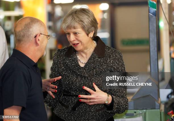 Britain's Prime Minister Theresa May talks with a member of staff as she visits textile producers Alex Begg in Ayr, Scotland, March 29 during a tour...