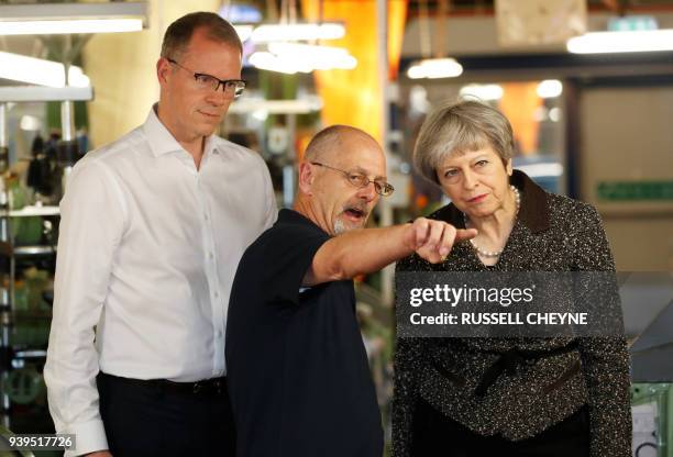 Britain's Prime Minister Theresa May talks with members of staff as she visits textile producers Alex Begg in Ayr, Scotland, March 29 during a tour...