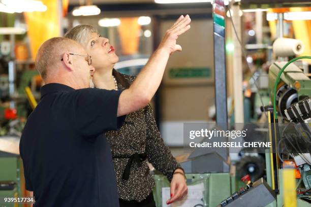 Britain's Prime Minister Theresa May talks with a member of staff as she visits textile producers Alex Begg in Ayr, Scotland, March 29 during a tour...