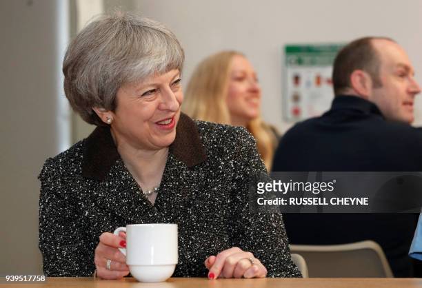 Britain's Prime Minister Theresa May talks with members of staff as she visits textile producers Alex Begg in Ayr, Scotland, March 29 during a tour...