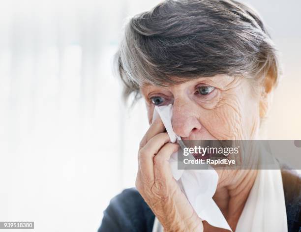 sad senior woman wiping eyes with tissue - handkerchief stock pictures, royalty-free photos & images