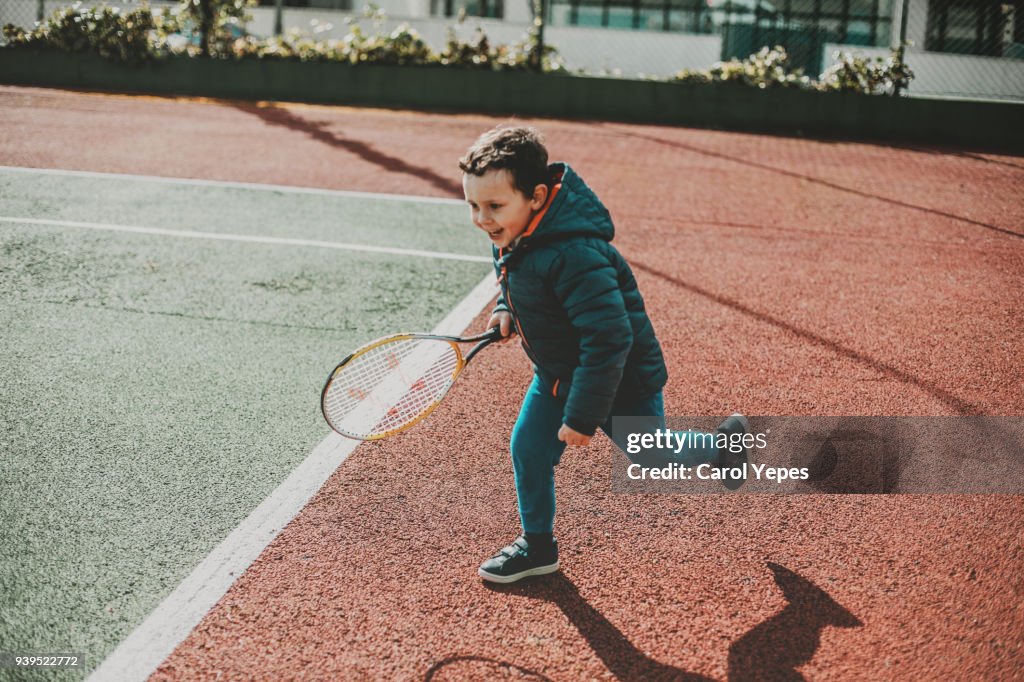Baby boy pretending to play tennis