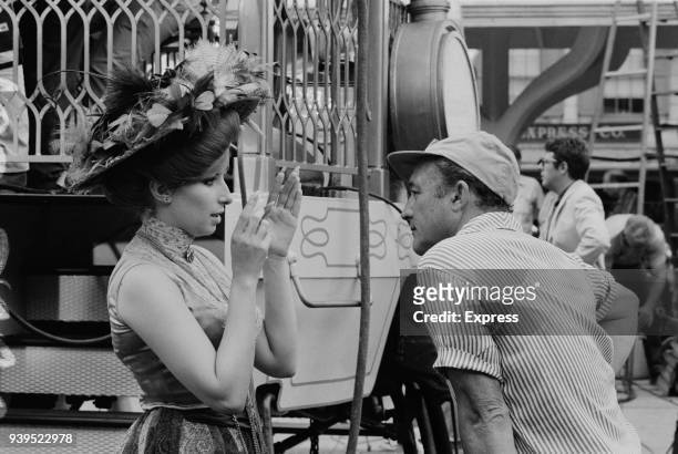 American singer, songwriter, and actress Barbara Streisand with director Gene Kelly on the set of romantic comedy musical film 'Hello, Dolly!', US,...