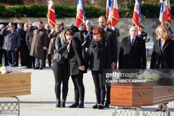 French Prime Minister Edouard Philippe , French Interior Minister Gerard Collomb and French Justice Minister Nicole Belloubet stand behind family...