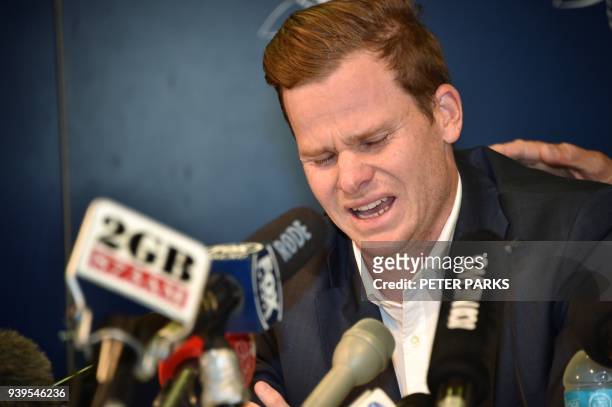 Cricketer Steve Smith reacts at a press conference at the airport in Sydney on March 29 after returning from South Africa. Distraught Australian...