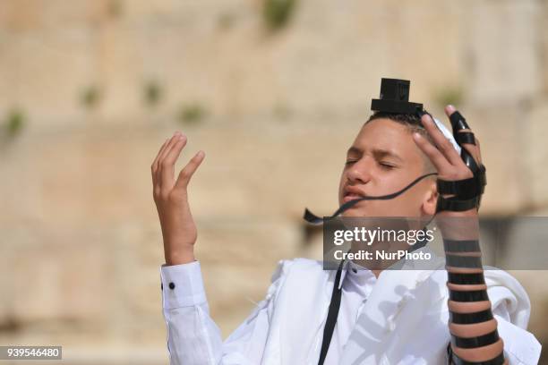 Bar mitzvah boy wearing tallit and tefillin at The Western Wall in the Old City of Jerusalem. Wednesday, 14 March 2018, in Jerusalem, Israel.