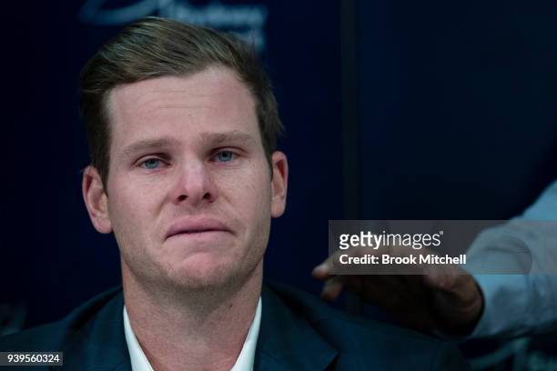 Steve Smith is comforted by his father Peter during a press conference at Sydney International Airport on March 29, 2018 in Sydney, Australia. Steve...