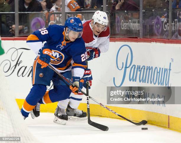 Sebastian Aho of the New York Islanders reaches for the puck against Byron Froese of the Montreal Canadiens during the second period at Barclays...